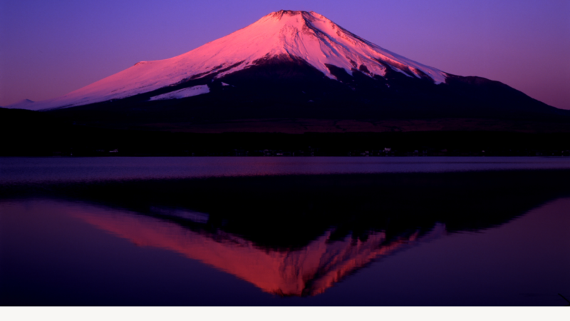 Dark winter scene of Mount Fuji under a night sky, reflected clearly on a still lake. A soft moonlight appears above the mountain. Text on the image reads: “Quiet Reflection Series #011. If 2025 had a word, what would yours be — and why? Thrive Life Design.”