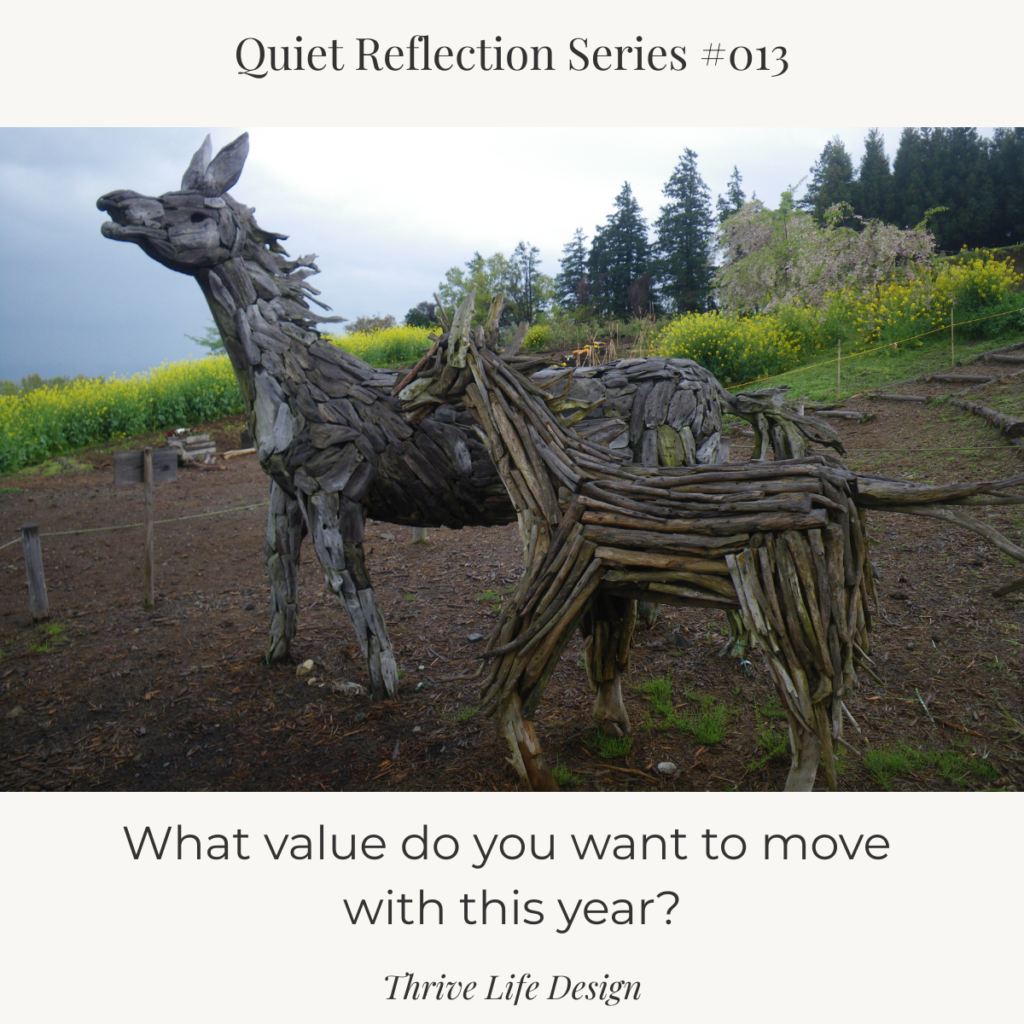 Canva graphic titled ‘Quiet Reflection Series No. 013.’ A warm-toned photograph shows two wooden toy horses—a larger one and a smaller one—standing side by side, suggesting a parent and child. Text on the image asks, ‘What value do you want to move with this year?’ ‘Thrive Life Design’ appears at the bottom.