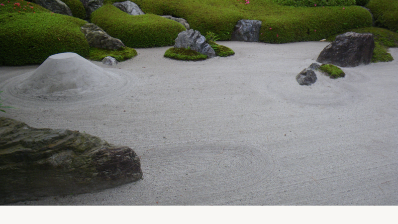 Photo of a karesansui (Japanese rock garden) in Kamakura, with carefully raked gravel and arranged stones, creating a quiet, minimalist scene.