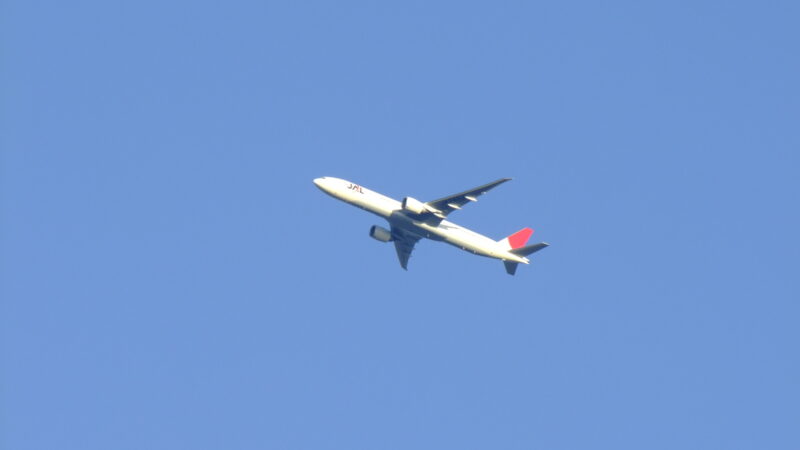 A Japan Airlines airplane flying across the sky.